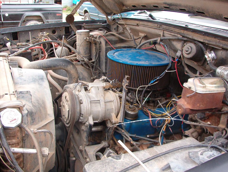 Engine bay with blue air filter and various hoses and wires