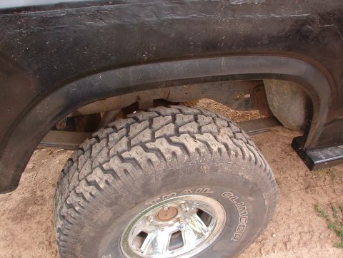 1985 Ford Bronco - Close-up of the rear wheel well on a 1985 Ford Bronco, showing the tire and fender.