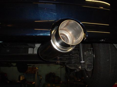 1993 Ford Taurus - Close-up of a car's exhaust pipe and rear tire, with visible text at the bottom.