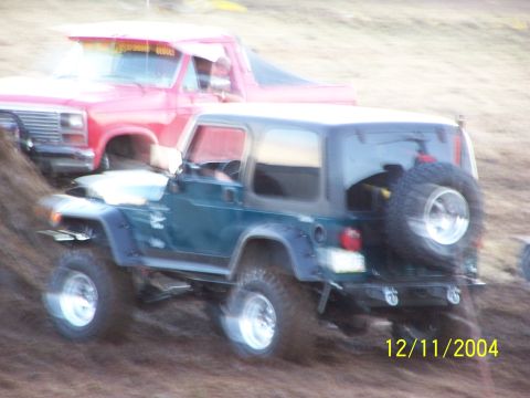 1985 Ford Bronco - A green Jeep Wrangler and a red Ford pickup truck navigate rough terrain, captured on December 11, 2004.