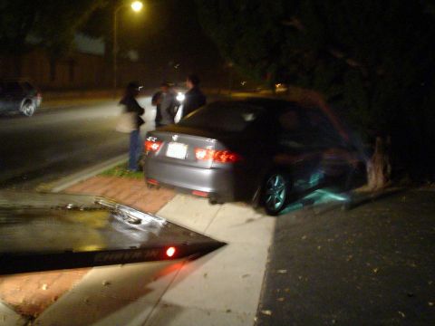 1993 Ford Taurus - A car is being loaded onto a tow truck at night, with several people observing the scene.