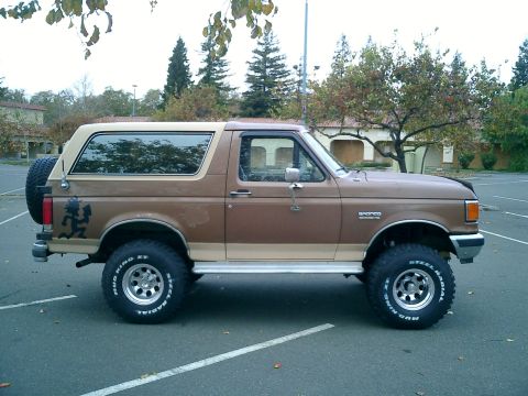 1990 Ford Bronco - This 1990 Ford Bronco features a lifted suspension and aftermarket wheels, with a spare tire mounted on the rear.