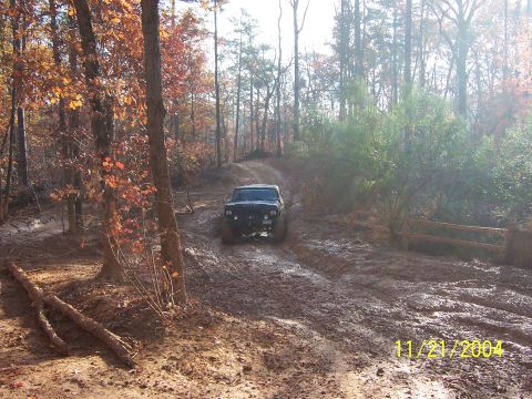1978 Ford Bronco - 1978 Ford Bronco navigating a challenging muddy track during an off-road excursion.