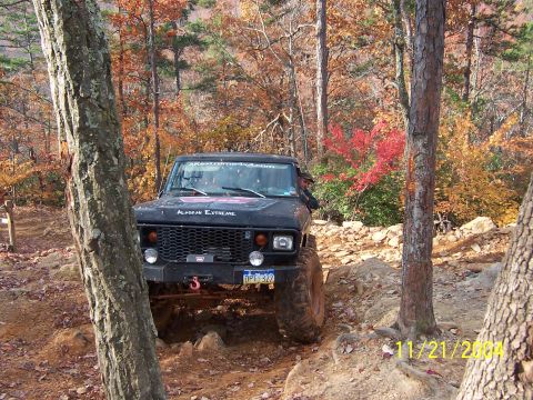 1978 Ford Bronco - This modified off-road vehicle navigates a challenging rocky path amidst autumn foliage.