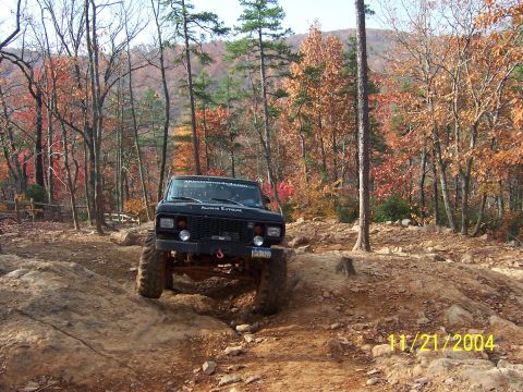1978 Ford Bronco - A modified off-road vehicle navigates a challenging rocky trail during autumn.
