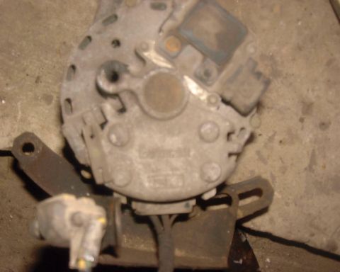 1985 Ford F-150 - This is a close-up view of a vehicle alternator, showing its internal components and external connections.
