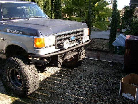 1989 Ford Bronco - Front view of a modified Ford Bronco with a custom bumper and off-road tires.