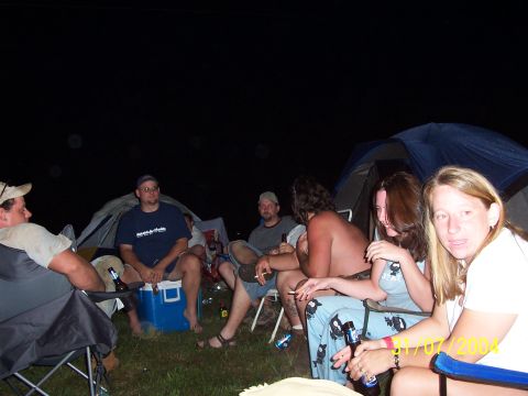 1979 Ford F-150 - People gather around a cooler at a campsite at night, with tents visible behind them.