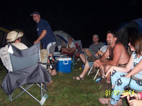 1979 Ford F-150 - People enjoying a camping trip at night, with tents set up around them.