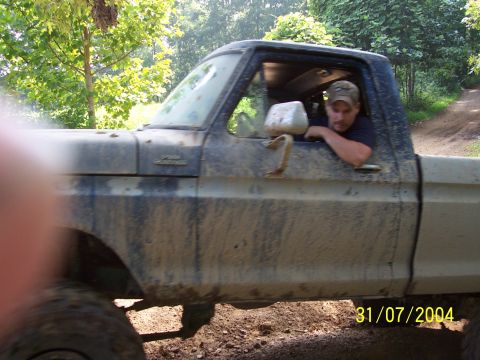 1979 Ford F-150 - Muddy 1979 Ford F-150 pickup truck driving off-road with driver.