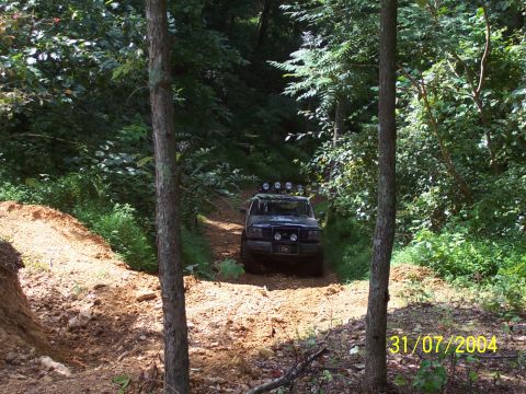1979 Ford F-150 - A vehicle navigates a wooded trail with a date stamp of 31/07/2004 in the corner.