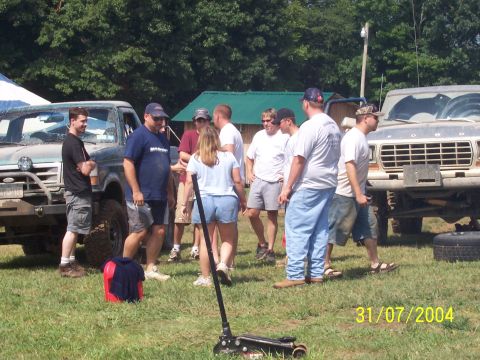 1979 Ford F-150 - A group of people stand around two trucks, one of which appears to be a 1979 Ford F-150.