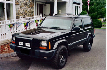 2000 Jeep Liberty - A black Jeep Cherokee is shown from a three-quarter front angle, parked outdoors.