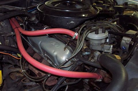 1985 Ford Crown Victoria LTD - Close-up of an engine bay red heater hoses and a Ford-branded valve cover. The registry information suggests a 1985 Ford Crown Victoria LTD…