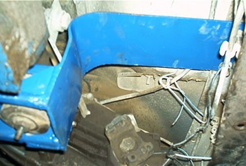 1986 Ford Bronco - Underside view of a blue painted crossmember and associated drivetrain components.