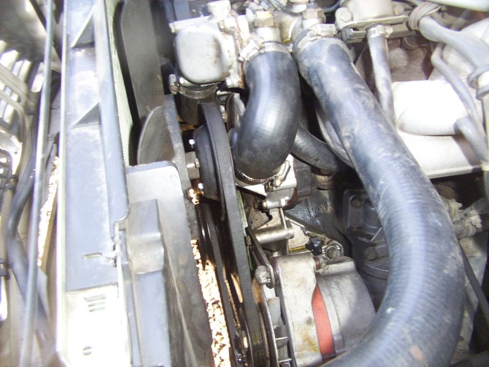 Engine bay close-up showing fan, belt, and hoses