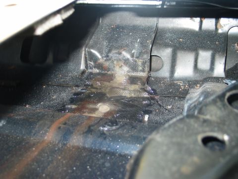 1995 Ford Bronco - Close-up view of the interior cargo area of a vehicle, revealing signs of rust and wear.