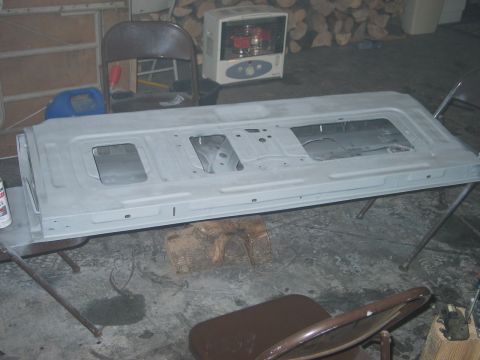 1995 Ford Bronco - A disassembled tailgate, prepped for painting, rests on sawhorses in a workshop setting.