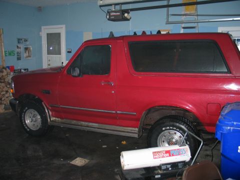 1995 Ford Bronco - Red Ford Bronco parked inside a garage, side view. Visible text on heater.