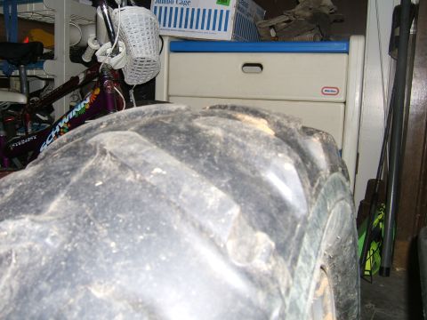 1978 Ford Bronco - A large tire dominates the foreground, with a bicycle and storage drawers in the background.