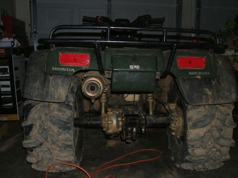 1978 Ford Bronco - This green Honda ATV is shown from the rear, large, mud-caked tires and a visible exhaust system.
