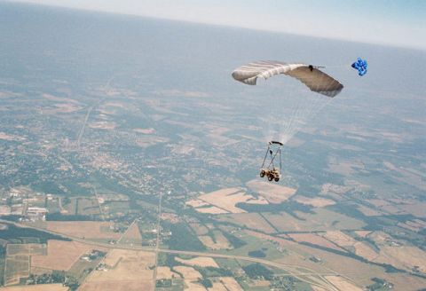 1993 Ford Bronco - A unique airborne vehicle, a powered parachute, transports a small cart over a vast expanse of farmland and scattered towns.