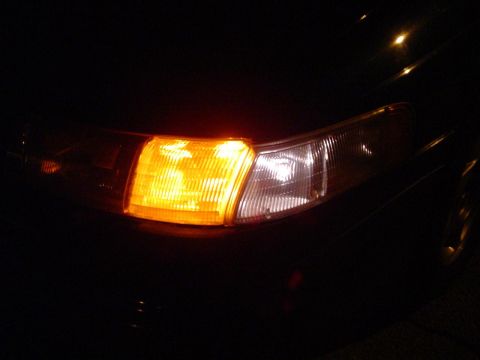 1993 Ford Taurus - The illuminated front turn signal and headlight of a 1993 Ford Taurus are visible in this nighttime shot.