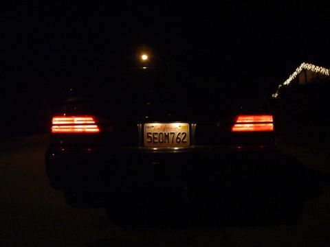 1993 Ford Taurus - Rear view of a 1993 Ford Taurus at night with its taillights illuminated.