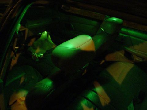 1993 Ford Taurus - The interior of a car is illuminated by green lighting, casting a glow on the seats and dashboard area.