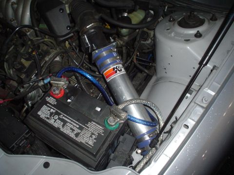 1993 Ford Taurus - Close-up view of a car's engine bay, showing the battery and air intake system.