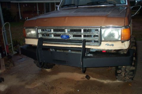 1987 Ford Bronco - The front of a brown 1987 Ford Bronco is shown with a new bumper and winch.