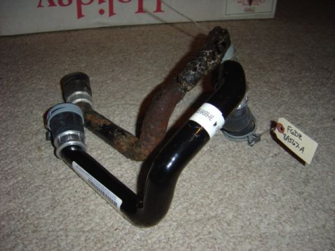 1998 Ford Taurus - Automotive radiator hoses, one black and one rusty, with a part identification tag.