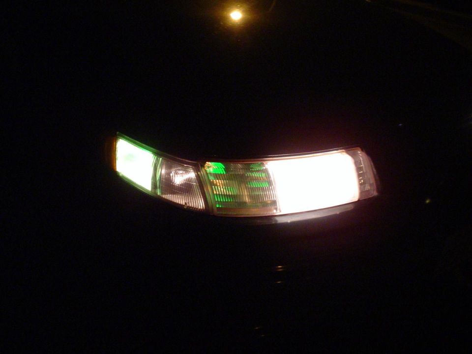 1993 Ford Taurus front passenger side headlight and amber turn signal illuminated at night