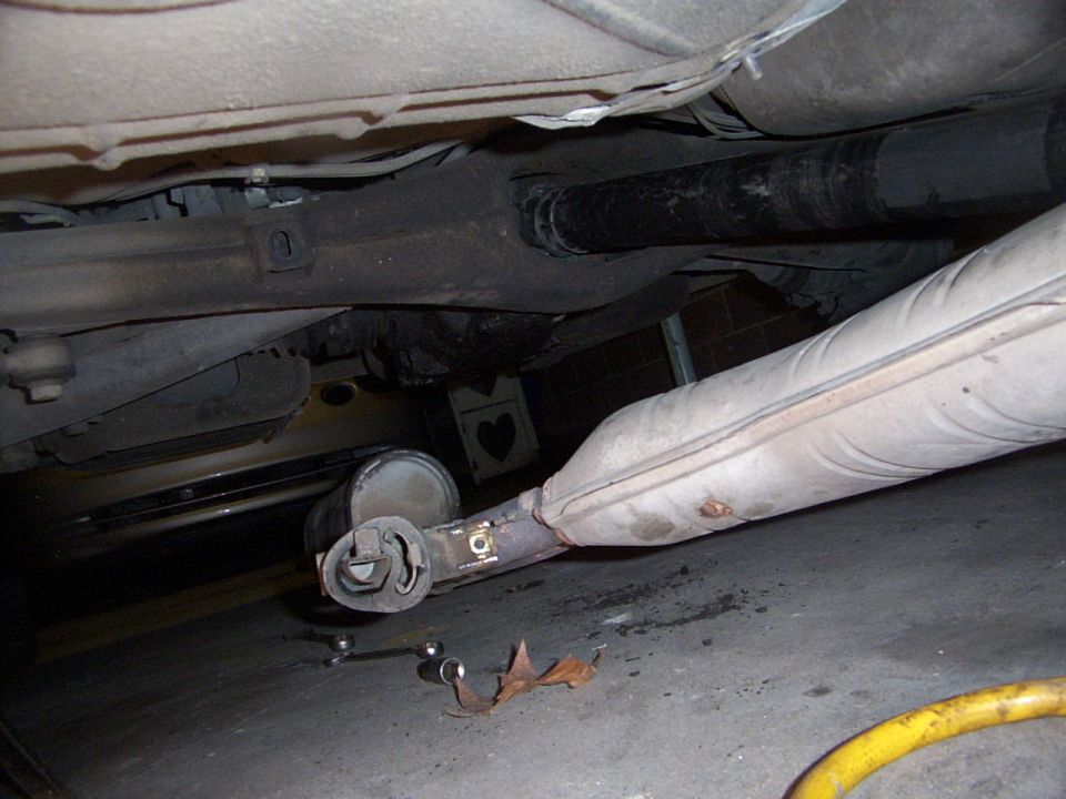 Underside view of a car's exhaust system, showing a muffler and pipe