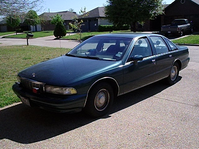 Dark green Chevrolet Caprice sedan, front three-quarter driver-side view, parked on a driveway