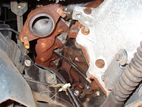 1994 Ford Crown Victoria - Close-up of a rusted exhaust manifold and engine block, likely from a donor vehicle.