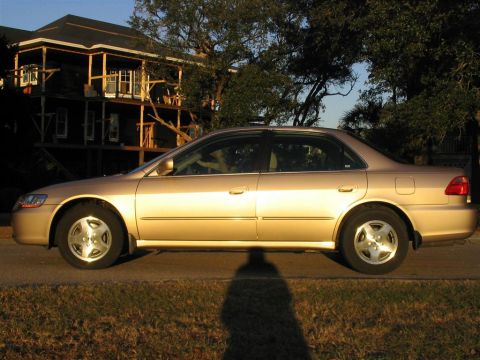 2000 Honda Accord - A gold sedan is parked on the side of the road with a house in the background.