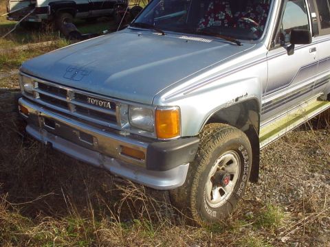 1988 Toyota 4Runner - Front end of a 1988 Toyota 4Runner, showing the grille and headlights. Another vehicle is in the background.