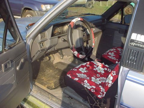 1988 Toyota 4Runner - The interior of a 1988 Toyota 4Runner features floral seat covers and a worn dashboard.