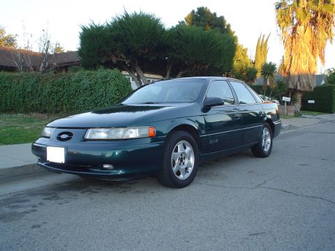 1993 Ford Taurus - This dark green 1993 Ford Taurus sedan is shown from a 3q-front angle on a residential street.