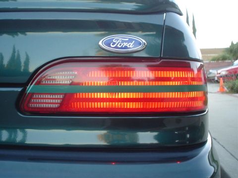 1993 Ford Taurus - Close-up of the rear driver side taillight assembly on a 1993 Ford Taurus, showing the Ford emblem above.