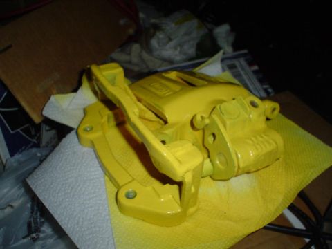 1993 Ford Taurus - A bright yellow brake caliper is shown, likely after being painted.