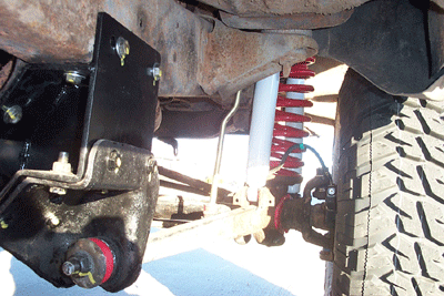 1978 Ford Bronco - Detail shot of suspension components, possibly from a lifted truck or SUV, showing red coil springs and black hardware.