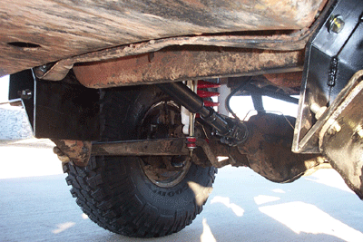 1978 Ford Bronco - Underside view of vehicle suspension components and tire.