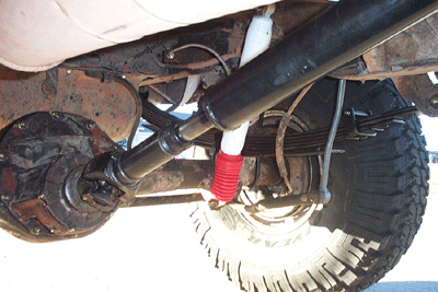 1978 Ford Bronco - Undercarriage view shows the suspension components of a vehicle, including the axle and a red shock absorber.
