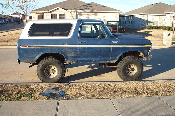 Side view of a blue 1978 Ford Bronco with a lift kit and white hardtop
