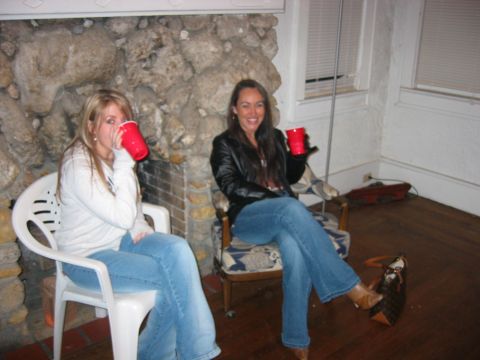 1989 Ford Bronco - Two women enjoy drinks at a party, with a stone fireplace in the background.