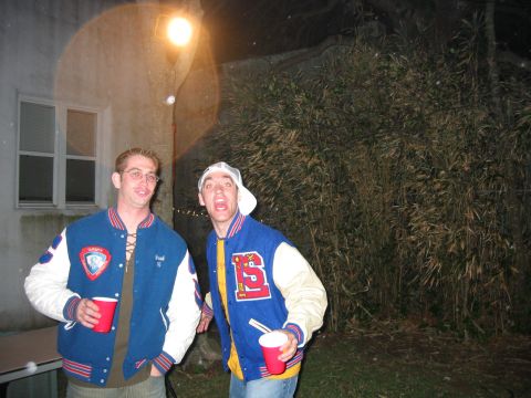 1989 Ford Bronco - Two men in varsity jackets pose for a photo at a nighttime gathering, with a bamboo-like plant in the background.
