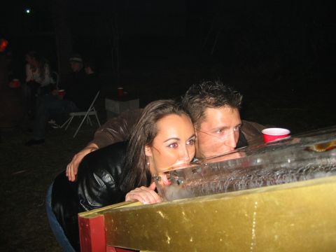 1989 Ford Bronco - A man and woman drink from a trough at a nighttime gathering.