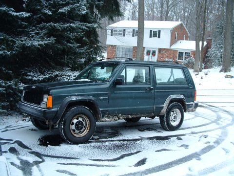 1994 Volkswagen Jetta - A two-door Jeep Cherokee XJ sits in the snow with tire tracks around it.